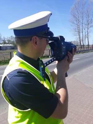 Policjant ruchu drogowego kontroluje prędkość ręcznym miernikiem