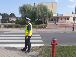 Policjant sprawdza przejście dla pieszych przy szkole